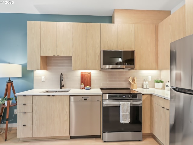 kitchen featuring stainless steel appliances, tasteful backsplash, light brown cabinets, and sink