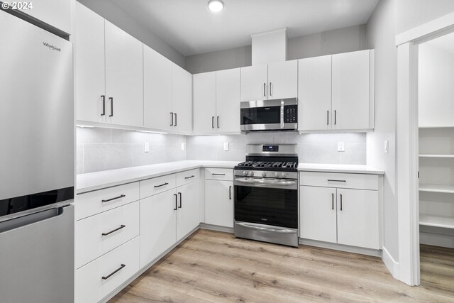 kitchen featuring white cabinetry, light wood-type flooring, and appliances with stainless steel finishes