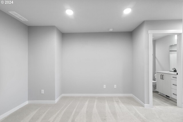 empty room featuring sink and light colored carpet