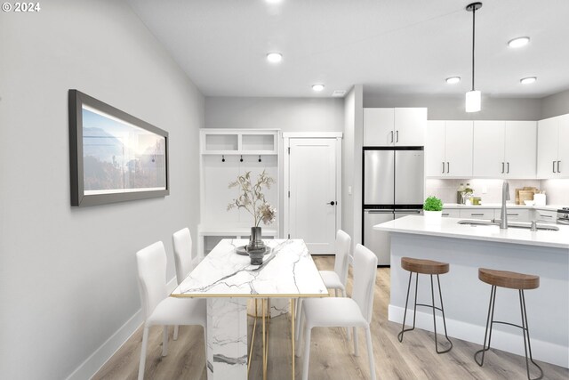 dining space featuring sink and light hardwood / wood-style floors