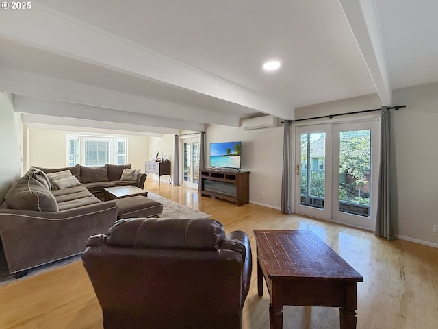 living room featuring beamed ceiling, light hardwood / wood-style flooring, and a wall mounted air conditioner