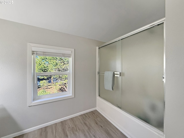 bathroom featuring bath / shower combo with glass door and hardwood / wood-style floors