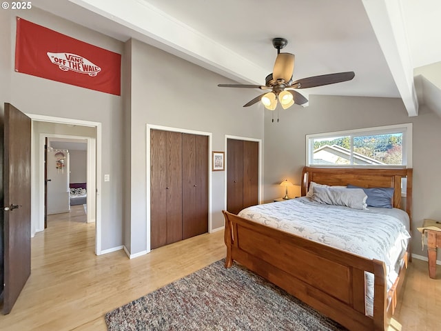 bedroom featuring beam ceiling, multiple closets, ceiling fan, and light hardwood / wood-style flooring