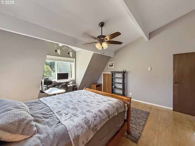 bedroom featuring ceiling fan, light hardwood / wood-style flooring, and vaulted ceiling with beams