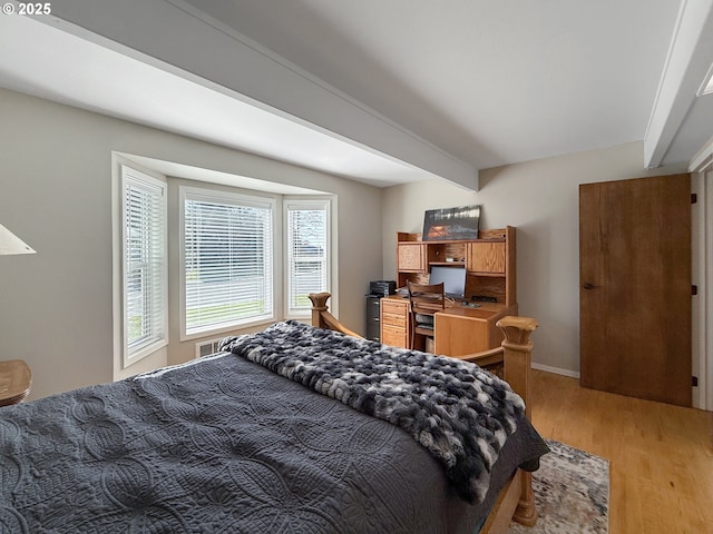 bedroom with hardwood / wood-style floors and beamed ceiling