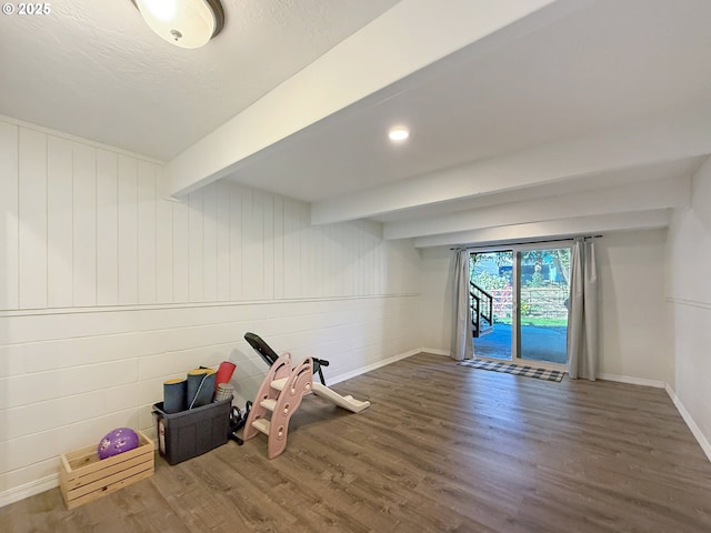 rec room featuring dark wood-type flooring and beam ceiling