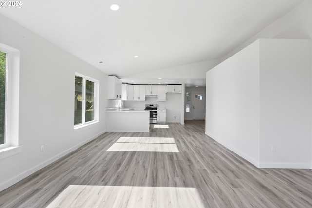 unfurnished living room with lofted ceiling, light hardwood / wood-style flooring, and plenty of natural light