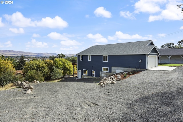 rear view of house featuring a mountain view and a garage