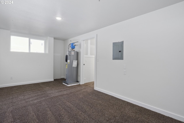 basement featuring dark colored carpet, electric panel, and electric water heater