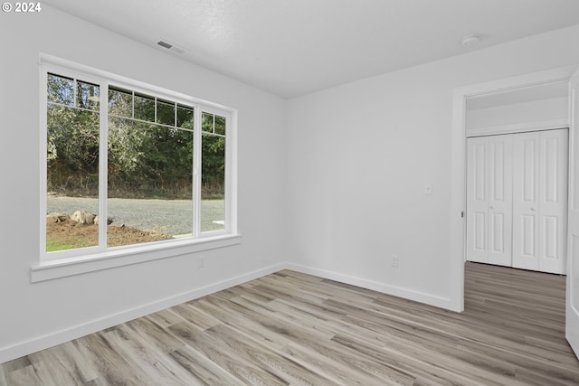 empty room featuring light wood-type flooring and a healthy amount of sunlight