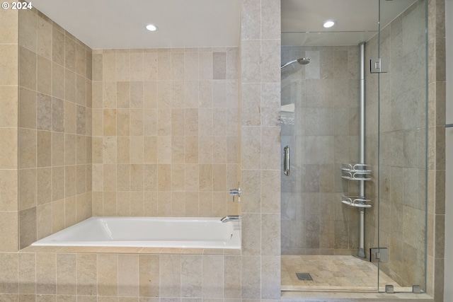 bathroom with separate shower and tub and tile walls