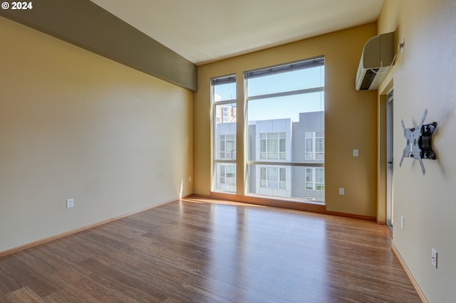 empty room with light hardwood / wood-style flooring and an AC wall unit