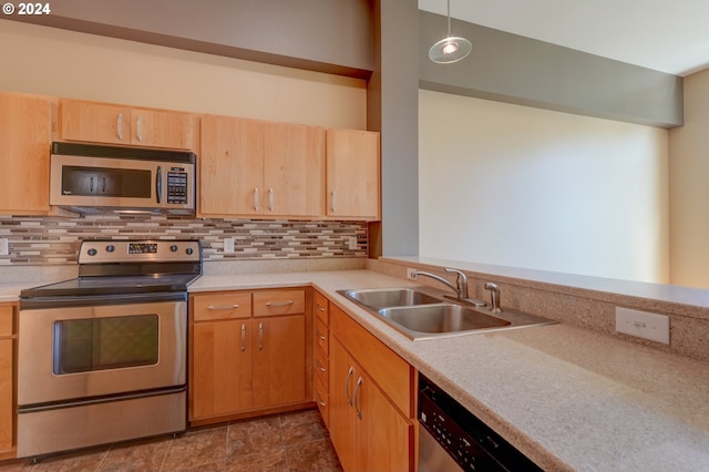 kitchen with light brown cabinets, sink, hanging light fixtures, tasteful backsplash, and stainless steel appliances