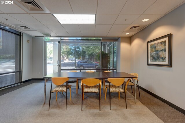 1125 NW 9th Ave Unit 524, Portland, OR 97209 - carpeted dining area featuring baseboards, plenty of natural light, floor to ceiling windows, and a paneled ceiling