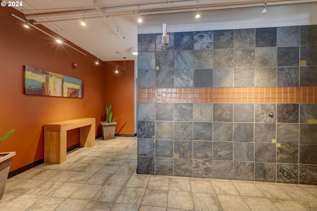 1125 NW 9th Ave Unit 524, Portland, OR 97209 - bathroom with track lighting, baseboards, and stone tile floors