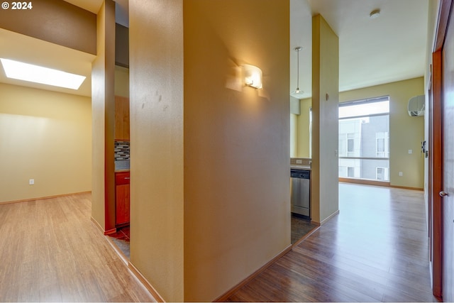 hallway featuring a skylight and hardwood / wood-style floors