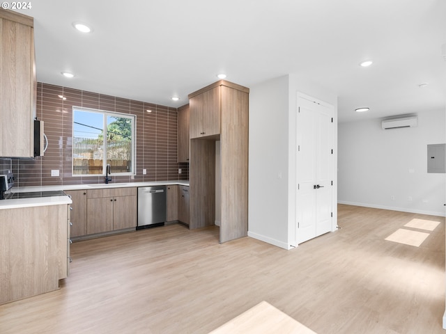 kitchen featuring a wall mounted AC, light wood-type flooring, stainless steel appliances, sink, and tasteful backsplash