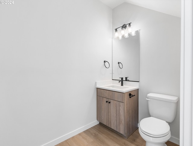 bathroom featuring vanity, toilet, and hardwood / wood-style flooring