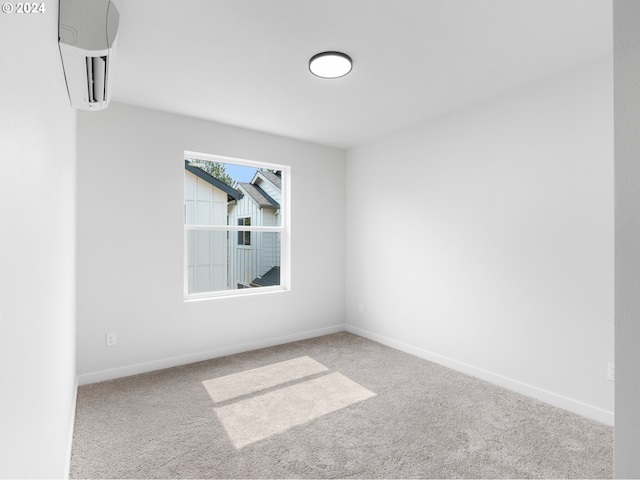 spare room with a wall unit AC and light colored carpet