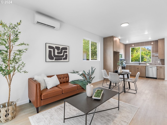 living room with plenty of natural light, light hardwood / wood-style floors, and a wall mounted air conditioner