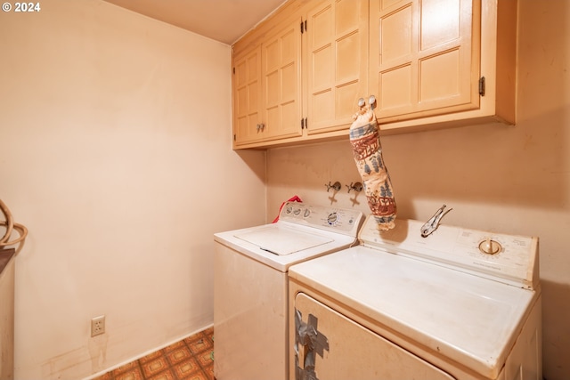 laundry room featuring washer and dryer and cabinets