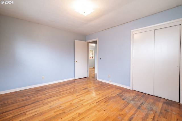 unfurnished bedroom featuring light wood-type flooring and a closet