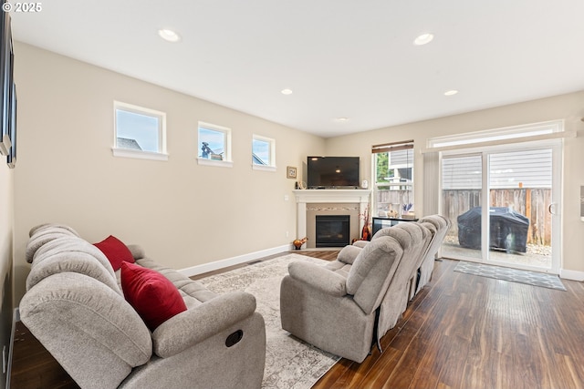 living area featuring dark wood-style floors, recessed lighting, a fireplace with flush hearth, and baseboards