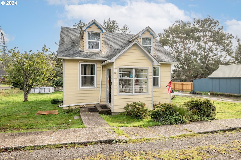 cape cod-style house with a front lawn