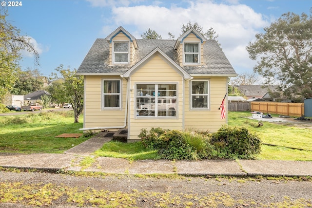 cape cod-style house with a front lawn