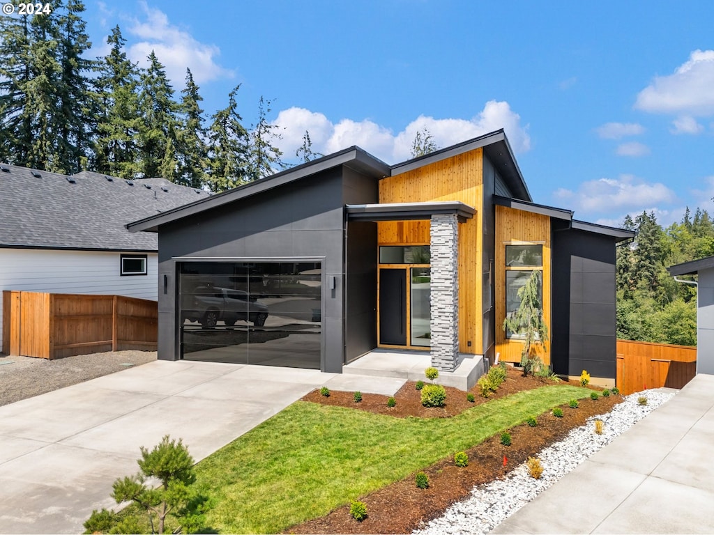 contemporary home with a front yard and a garage