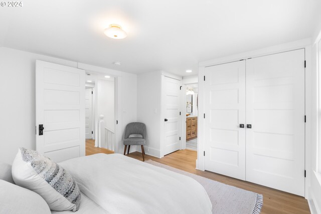 bedroom with light hardwood / wood-style floors and a closet