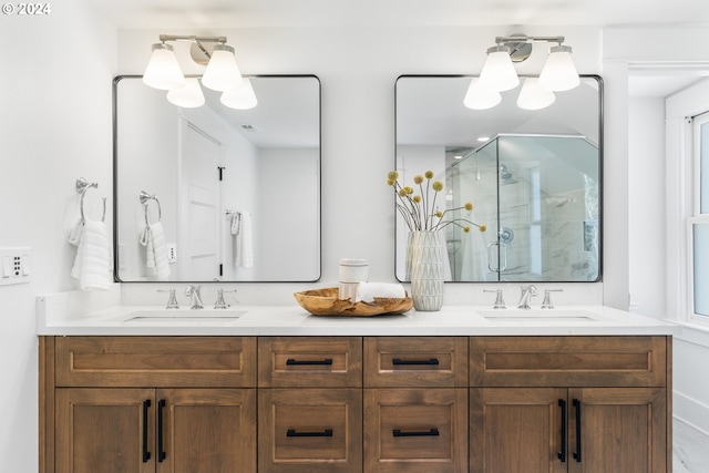 bathroom featuring a chandelier, dual vanity, and a shower with door