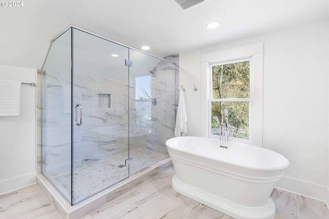 bathroom featuring independent shower and bath, tile flooring, and a wealth of natural light