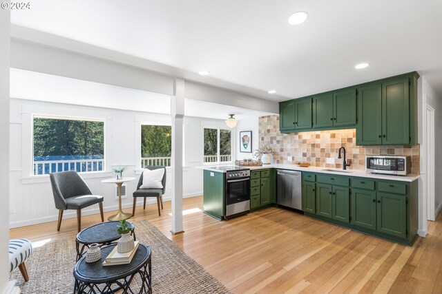 kitchen with plenty of natural light, light hardwood / wood-style floors, sink, and stainless steel appliances