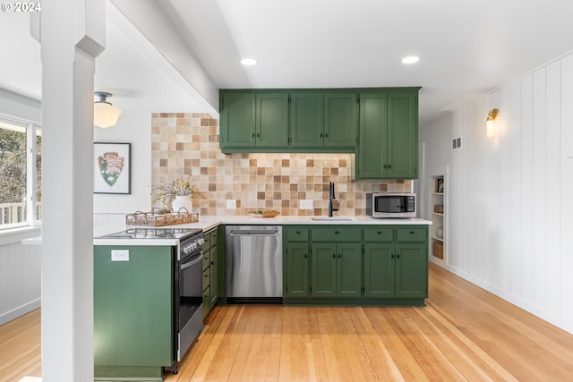 kitchen featuring green cabinets, light hardwood / wood-style floors, and appliances with stainless steel finishes