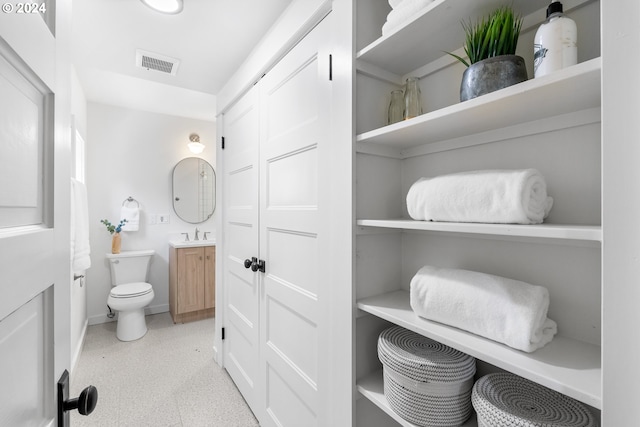 bathroom with tile floors, toilet, and vanity