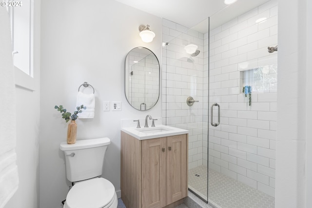 bathroom with toilet, a shower with door, and vanity with extensive cabinet space