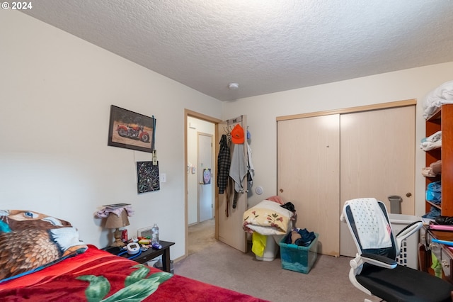 bedroom with light carpet, a textured ceiling, and a closet