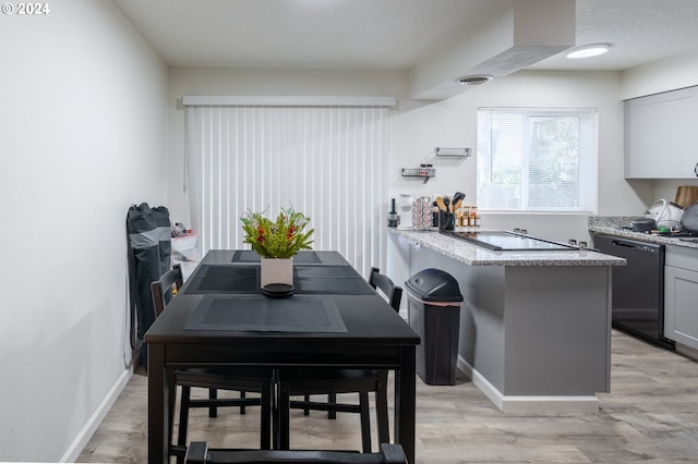 dining space featuring light hardwood / wood-style flooring and a textured ceiling