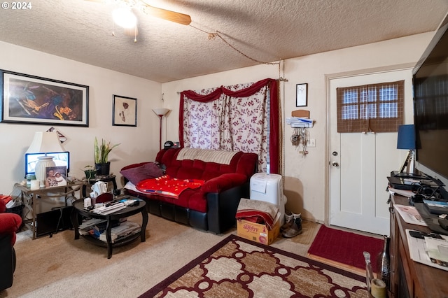 living room with a textured ceiling, carpet floors, and ceiling fan