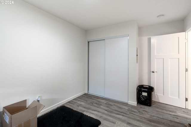 unfurnished bedroom with wood-type flooring and a closet