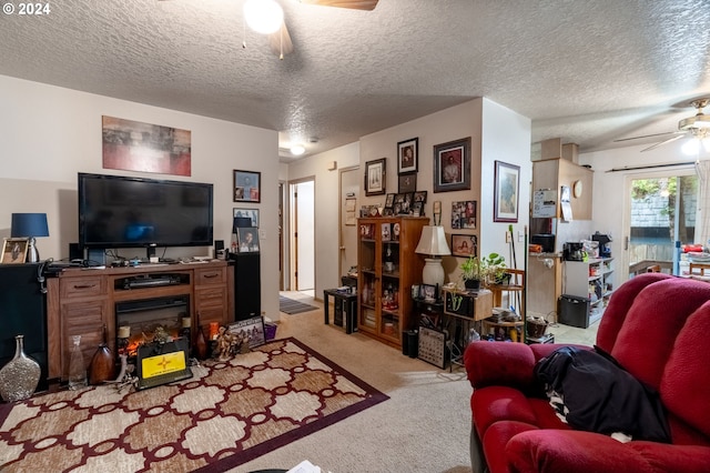 carpeted living room featuring ceiling fan and a textured ceiling