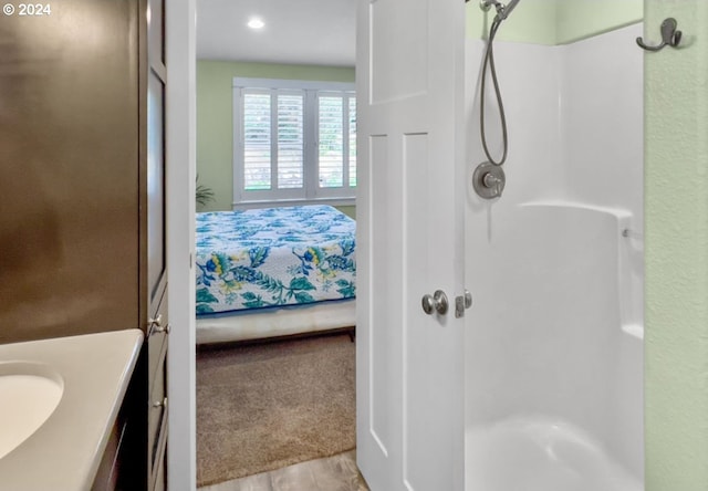 bathroom featuring vanity, a shower, and wood-type flooring