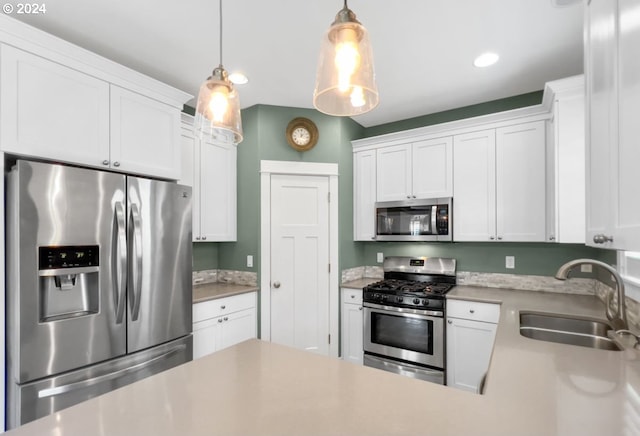 kitchen with pendant lighting, white cabinets, appliances with stainless steel finishes, and sink