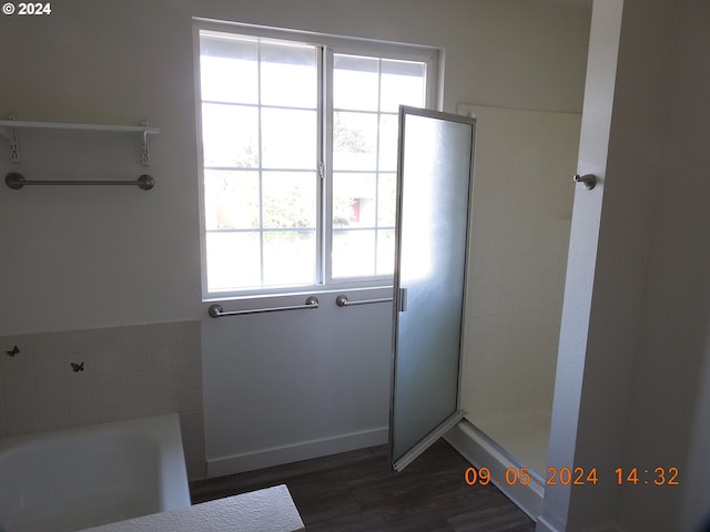 bathroom with wood-type flooring and independent shower and bath