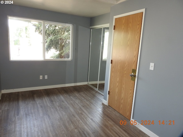 unfurnished bedroom with hardwood / wood-style flooring and a closet