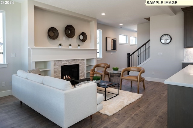 living room featuring dark wood finished floors, a fireplace, stairway, and baseboards