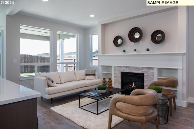 living room with a fireplace, baseboards, wood finished floors, and recessed lighting