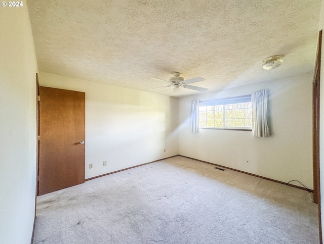 carpeted spare room with ceiling fan and a textured ceiling