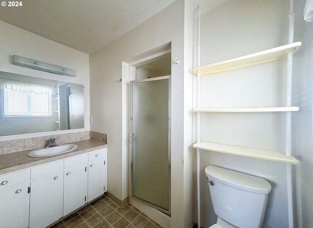 bathroom with a shower with door, vanity, a textured ceiling, and toilet